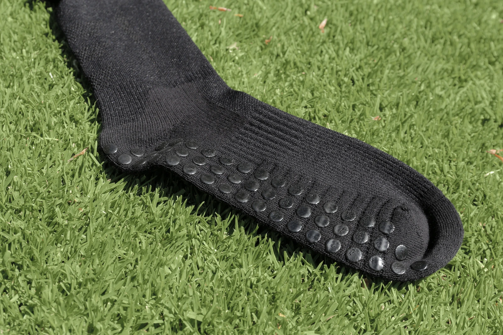 Grip dots under the sole of black Grip Cut Socks.